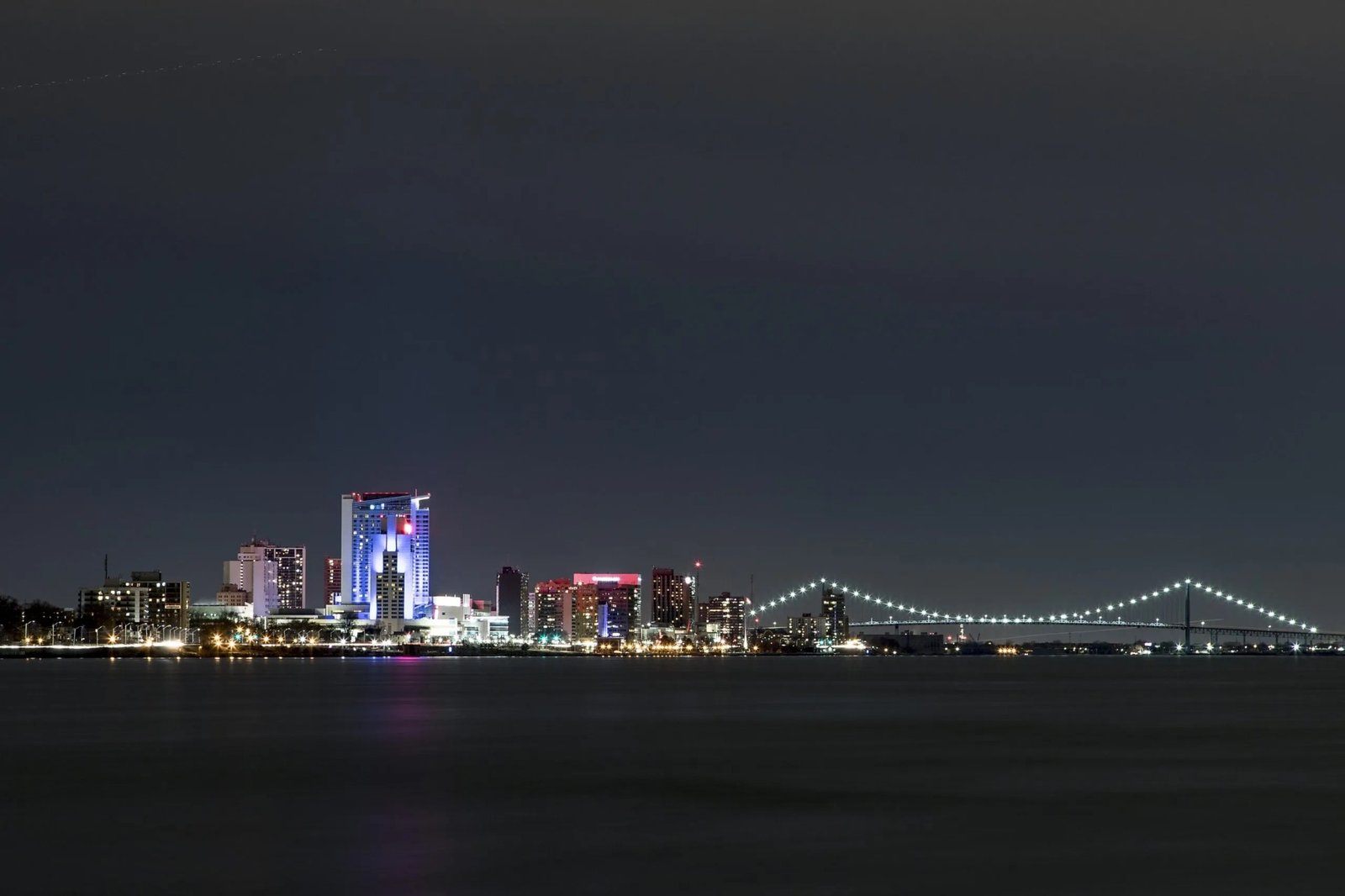 Downtown Windsor skyline and Ambassador Bridge at night, viewed across the Detroit River